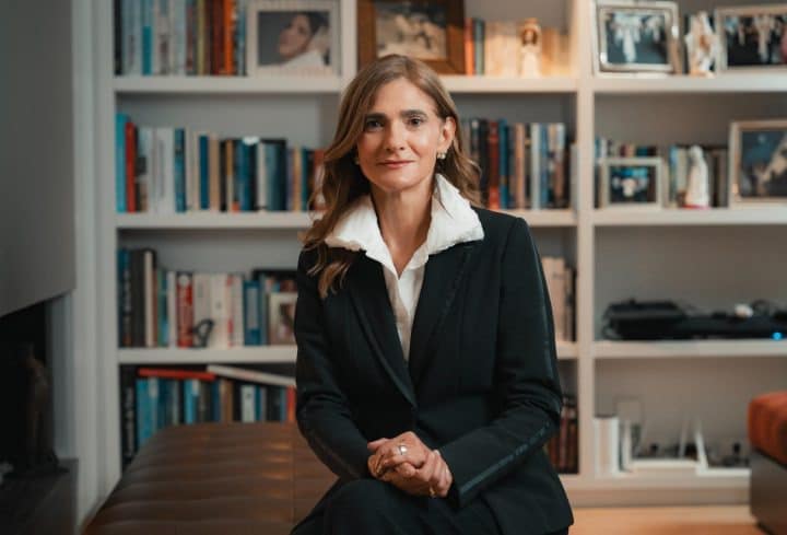 Ángela María Orozco sonríe en su oficina con documentos de Avianca en la mesa.