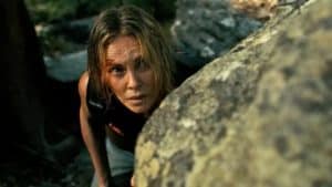 Charlize Theron y Taron Egerton en un paisaje montañoso, listos para una escena intensa de acción.