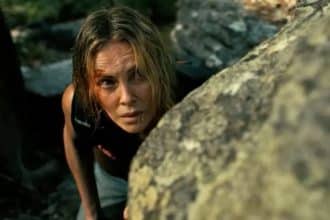 Charlize Theron y Taron Egerton en un paisaje montañoso, listos para una escena intensa de acción.