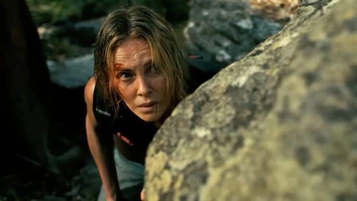 Charlize Theron y Taron Egerton en un paisaje montañoso, listos para una escena intensa de acción.