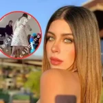 Carolina Flores Gómez sonríe en un evento, vestida con un elegante vestido de gala y rodeada de flores.