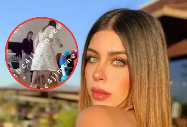 Carolina Flores Gómez sonríe en un evento, vestida con un elegante vestido de gala y rodeada de flores.