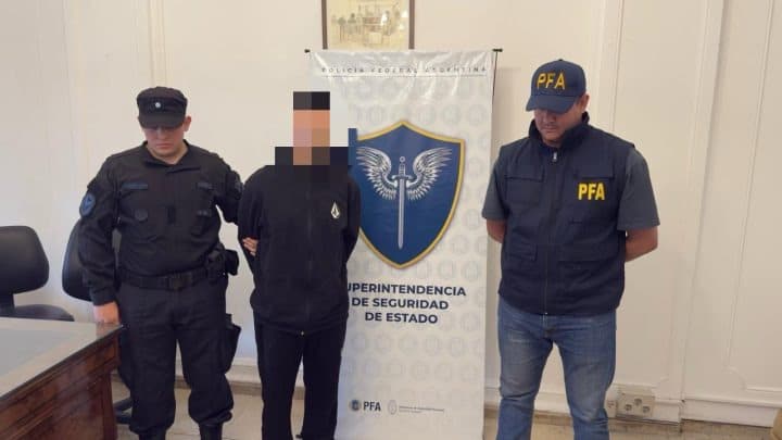 Braian Ferney Cruz es conducido por policías en Buenos Aires, rodeado de reporteros.