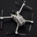 Un dron Lito X1 vuela sobre un paisaje verde, mientras un principiante lo controla con una sonrisa.