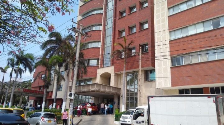 Un grupo de médicos discute en una sala de espera de un hospital, con documentos en mano.