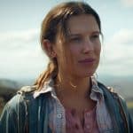 Millie Bobby Brown en una sesión de fotos, luciendo un vestido colorido con fondo de estudio.