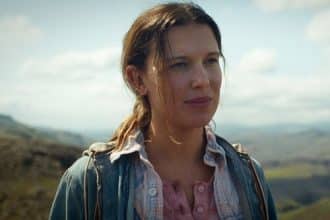 Millie Bobby Brown en una sesión de fotos, luciendo un vestido colorido con fondo de estudio.