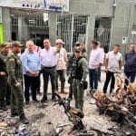 Un grupo de personas se reúne en un monumento en La Plata, con flores y velas en memoria de las víctimas.