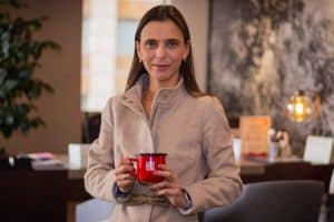 Camila Escobar sonríe mientras sostiene un café en un evento de Procafecol.