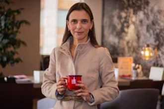 Camila Escobar sonríe mientras sostiene un café en un evento de Procafecol.