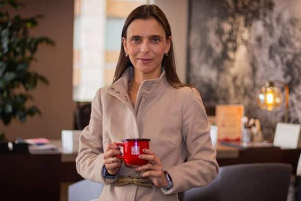 Camila Escobar sonríe mientras sostiene un café en un evento de Procafecol.