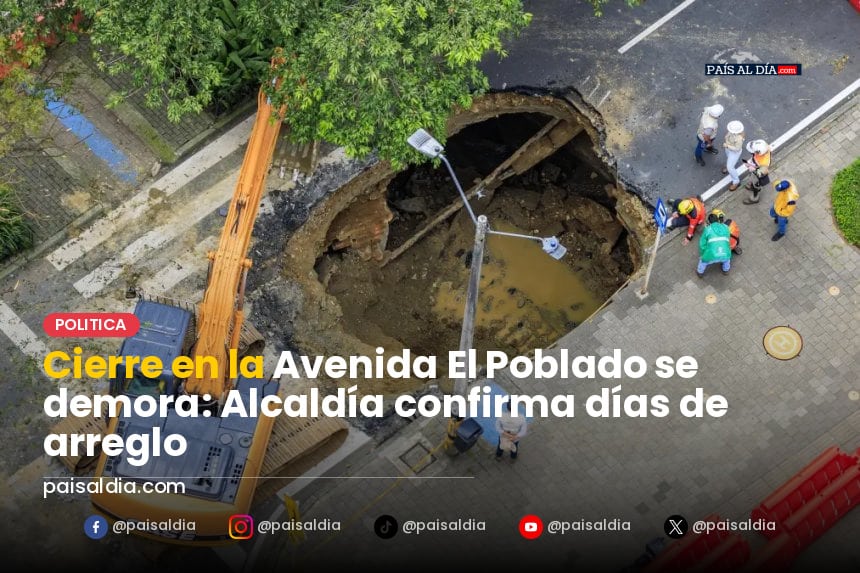 Trabajadores realizan reparaciones en la Avenida El Poblado, con maquinaria pesada y señalización de advertencia.