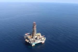 Equipos de perforación trabajan en el mar Caribe colombiano, con plataformas y barcos de apoyo en acción.