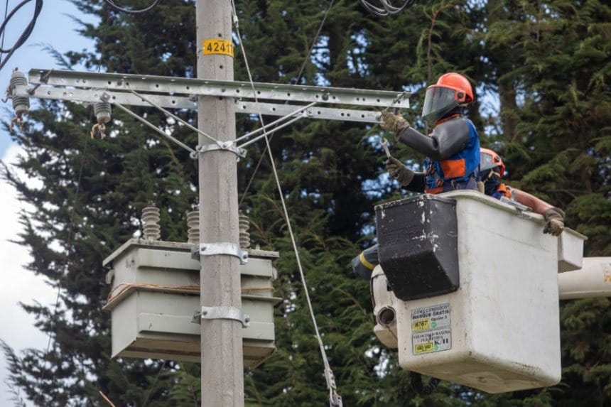 Varias personas haciendo fila en la Feria de Empleo en Fontibón, con mesas de empresas y folletos visibles.