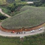 El gobernador Rodrigo Villalba firma documentos en una reunión con funcionarios, mapas y planos de obras viales en la mesa.