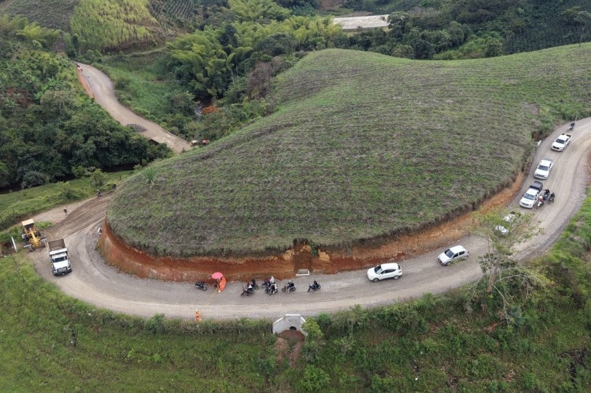El gobernador Rodrigo Villalba firma documentos en una reunión con funcionarios, mapas y planos de obras viales en la mesa.
