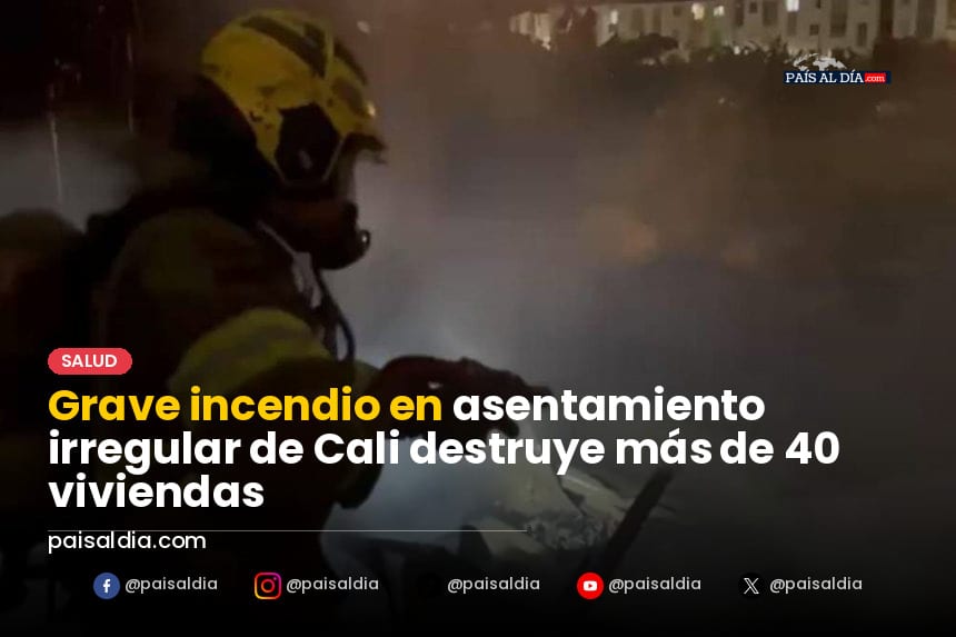 Humo denso y llamas iluminan la noche en el barrio Los Lagos, Cali, mientras bomberos trabajan para controlar el fuego.