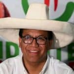 Un grupo de simpatizantes de la izquierda ondea banderas en una plaza llena de gente, celebrando los resultados electorales.