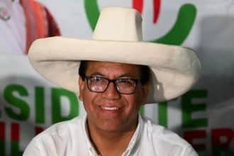 Un grupo de simpatizantes de la izquierda ondea banderas en una plaza llena de gente, celebrando los resultados electorales.