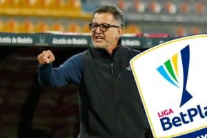 Juan Carlos Osorio en una conferencia de prensa, con micrófono en mano y fondo de logos de Atlético Bucaramanga.