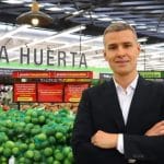 Juan Lucas Vega sonríe mientras sostiene un documento oficial en su nueva oficina.