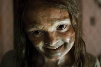 Escena de una oscura cueva iluminada por antorchas, con sombras tenebrosas.