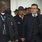 Olmedo López saliendo del Tribunal Superior de Bogotá, con expresión seria y rodeado de periodistas.