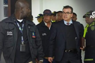 Olmedo López saliendo del Tribunal Superior de Bogotá, con expresión seria y rodeado de periodistas.