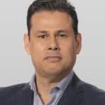 Christian Gaxiola, gerente de Bimbo Colombia, presenta los Pingüinos en un evento, rodeado de productos y asistentes entusias