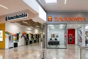 La sede de Bancolombia en Medellín, con empleados en la entrada y clientes en espera.