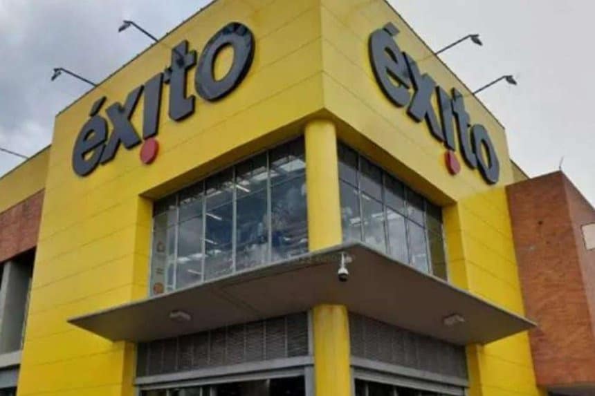 Carlos Mario Giraldo en una conferencia de prensa, con fondo de logos del Grupo Éxito.