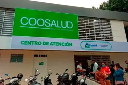 Edificio de Coosalud EPS en Cartagena, con un grupo de empleados conversando afuera.