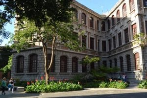 Estudiantes de medicina en la UdeA discuten sobre el proceso de admisión en un aula llena de libros y material médico.
