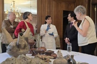 Piezas agustinianas expuestas sobre una mesa en un evento formal en Santiago.