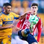 Jugadores de Tigres celebran un gol en el Estadio Universitario, con la afición vitoreando al fondo.