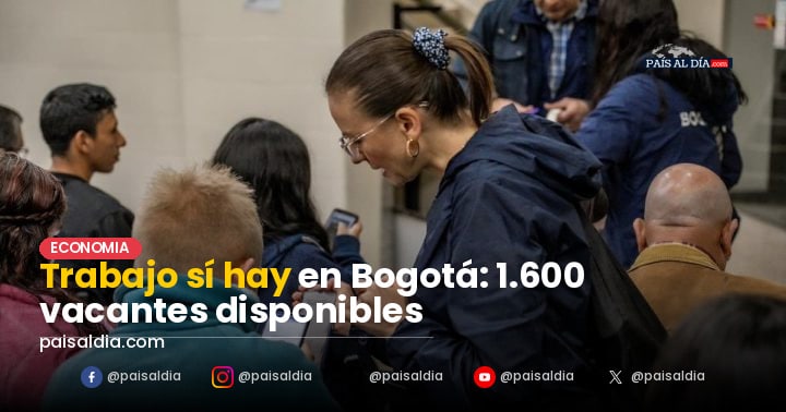Un grupo diverso de personas en una feria de empleo en Bogotá, conversando con reclutadores.
