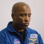 Victor Glover en el Centro Espacial Johnson, con expresión seria y micrófono en mano.