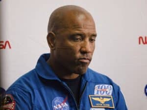 Victor Glover en el Centro Espacial Johnson, con expresión seria y micrófono en mano.