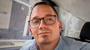 Wilmar Mejía en una conferencia de prensa, rodeado de periodistas y micrófonos.